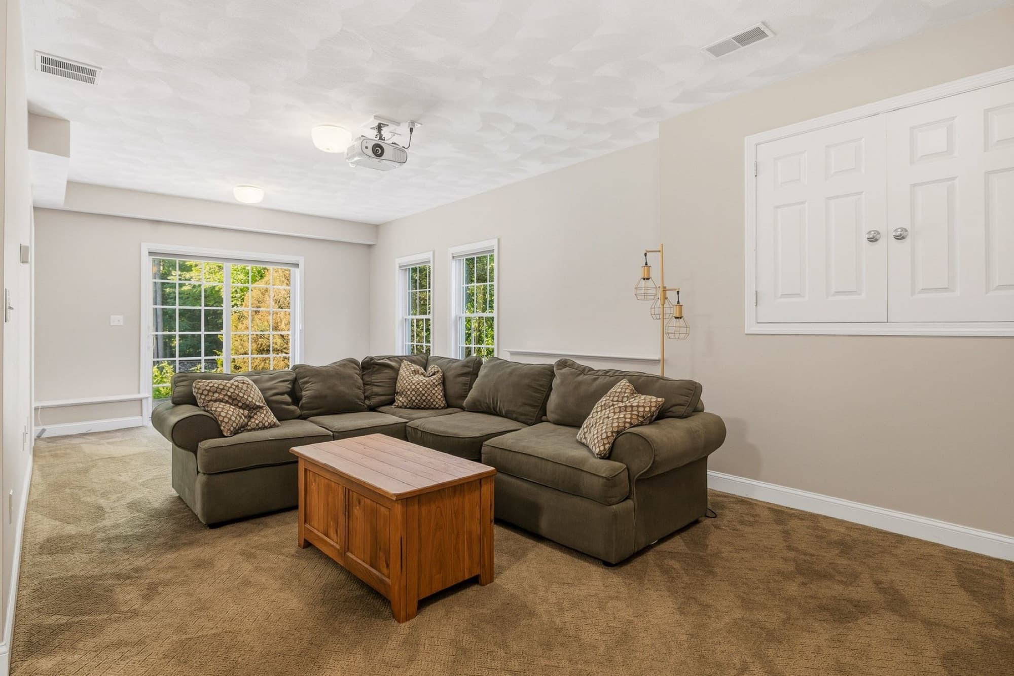 The lower-level family room with a sectional sofa, 2 windows, and a built-in cabinet