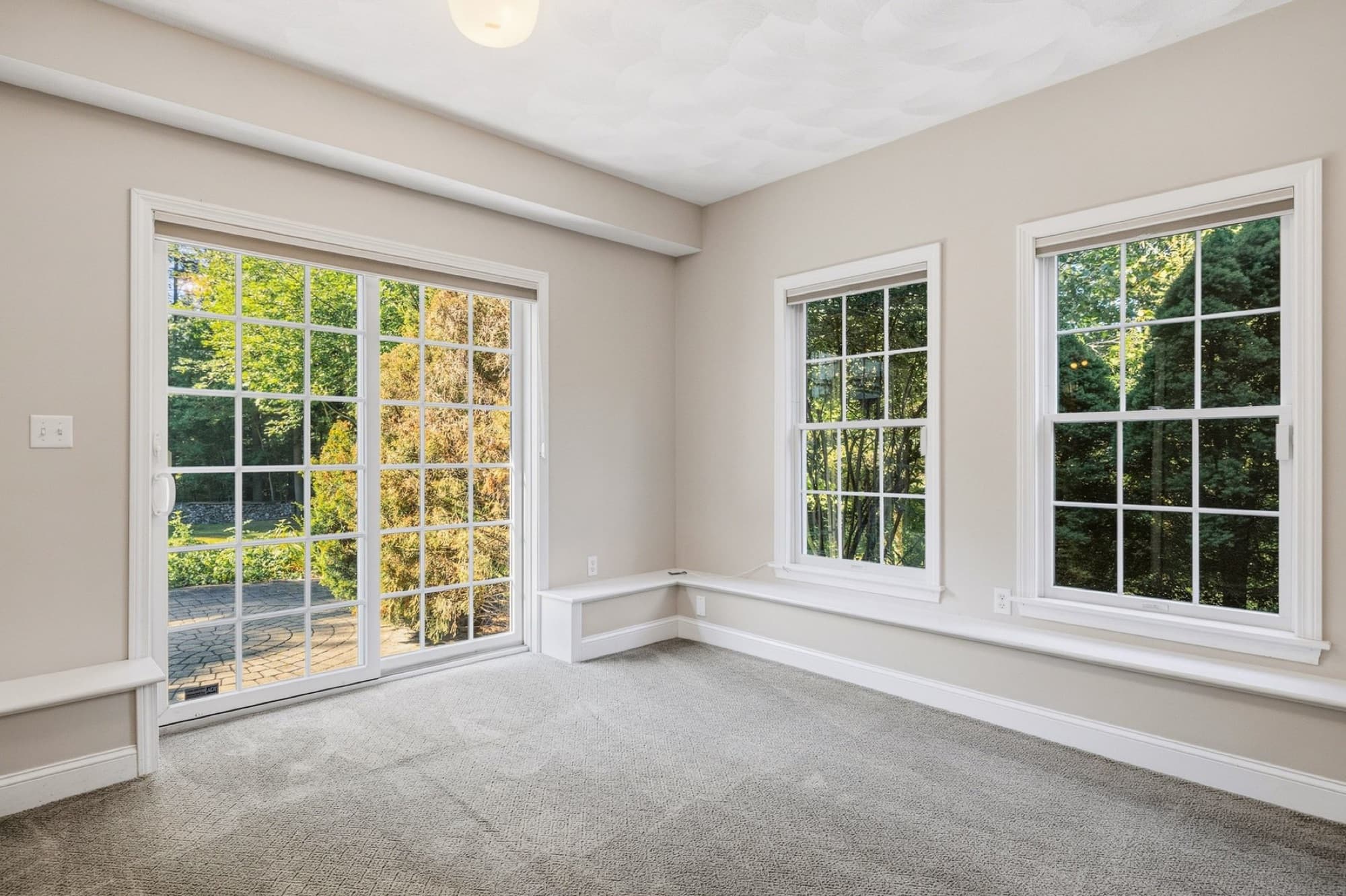 The lower-level family room's walkout end, with sliding glass doors and 2 windows