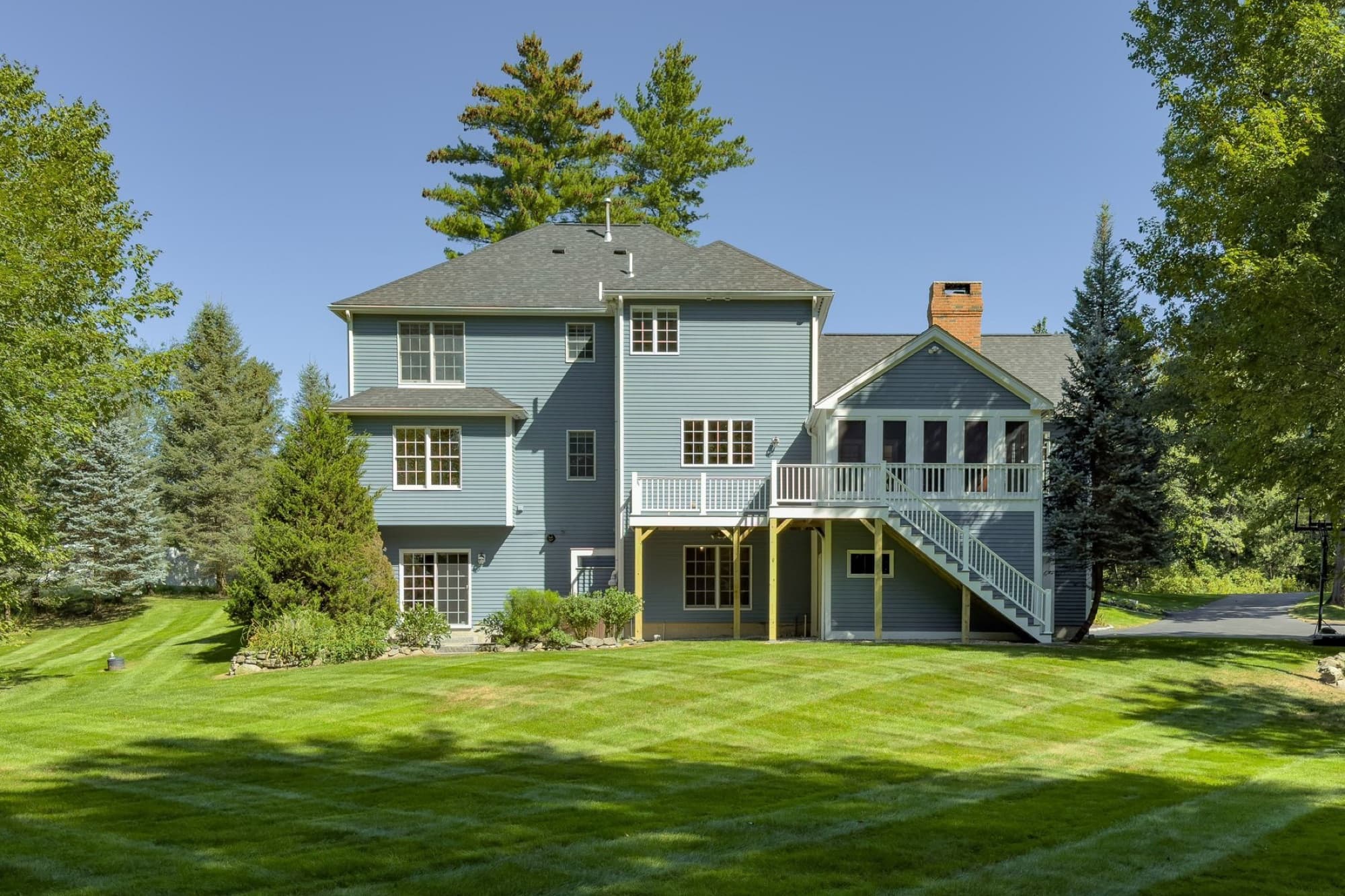 The back of the house from the lawn, with the 3-season porch, the deck, and the stairs down
