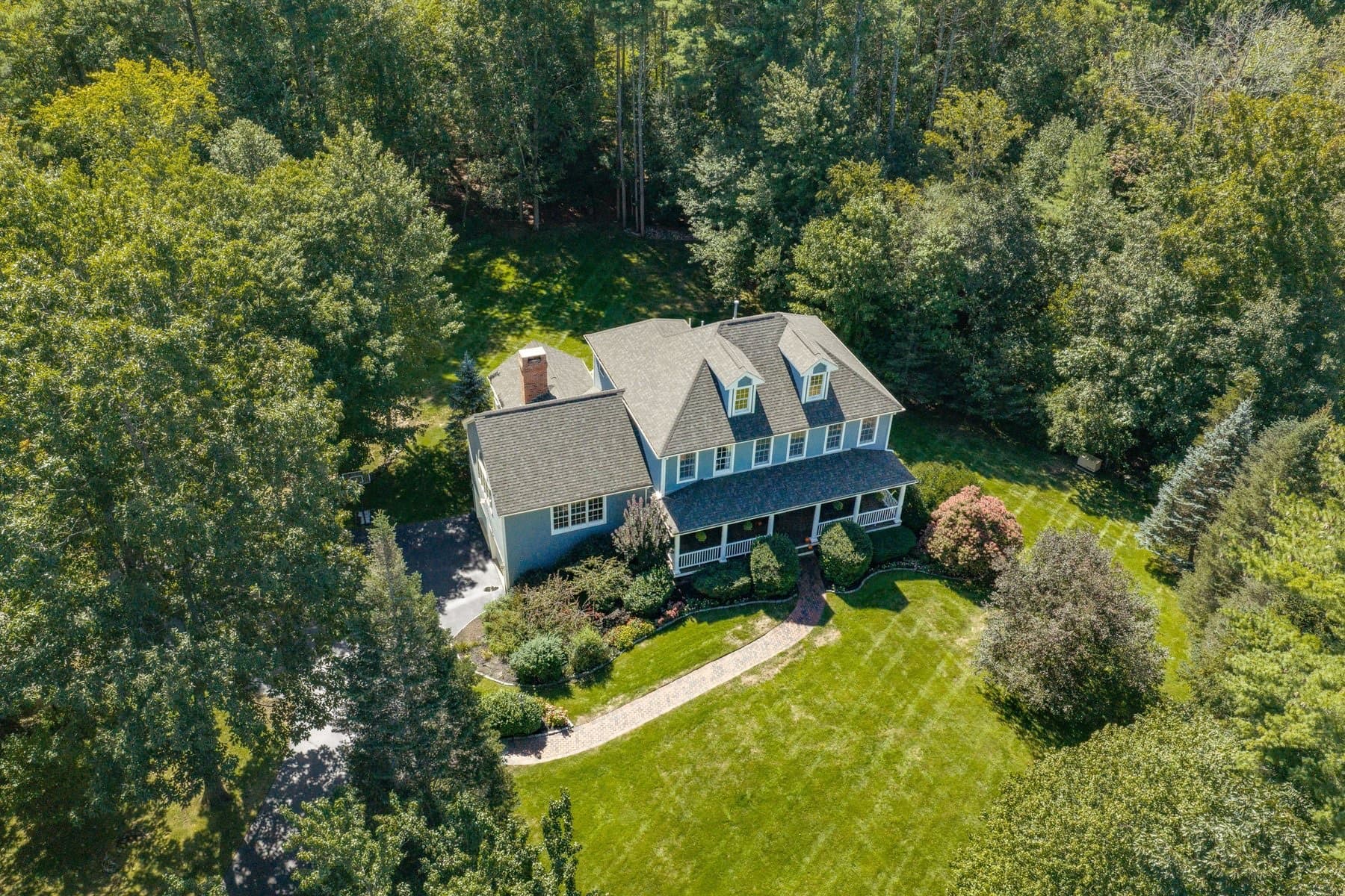 The house from the air, surrounded by lawn and woods